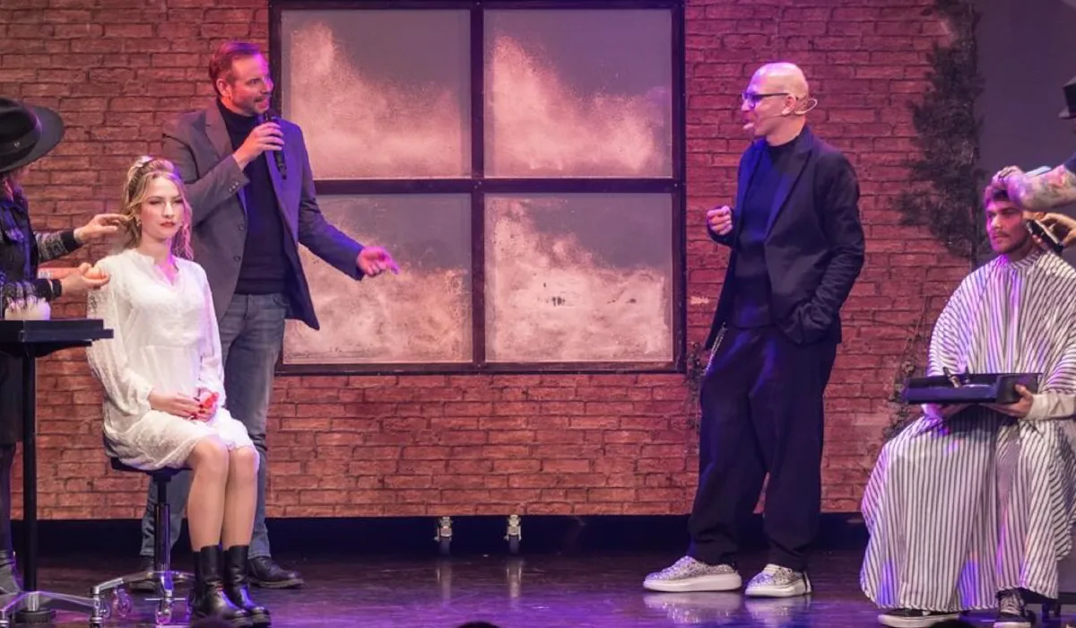 Thomas Dickenbrok bei einer Live-Moderation auf der Bühne mit Mikrofon und Gästen